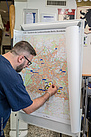 Auf einem Stadtplan oder einer Landkarte markiert der Helfer die Orte, an denen THW-Einsatzkräfte eingesetzt sind. Quelle: THW/ Anja Villwock