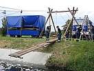 Die THW-Helfer verbinden zwei Sechs-Meter-Bohlen, die nun als Lauffläche für den Hängesteg dienen. Quelle: THW/ Anja Villwock