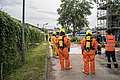 Feuerwehrmänner und -frauen sind auf dem Neuköllner  THW-Übungsgelände mit Schutzanzügen unterwegs. Quelle: THW/ Anja Villwock