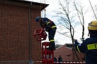 Der Helfer stapelt eine Kiste nach der anderen übereinander und muss dabei den Turm immer weiter hochklettern. Verliert er das Gleichgewicht, hängt er sicher im Auffanggurt am Seil. Quelle: THW/ M. Becker