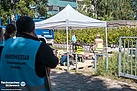 Das Sicherheitspersonal an der Corona-Abstrichstelle erhält ein Zelt, damit die Mitarbeitenden vor Sonne und Regen geschützt sind. Quelle: THW/ Yannic Winkler