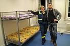 Und fertig ist das Doppelstockbett, erbaut in Teamarbeit von einer THW-Helferin und einem Faceboot-Freiwilligen. Quelle: THW/Joachim Schwemmer