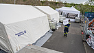 Die THW-Einsatzkräfte aus Neukölln und Lichtenberg stellen Zelte und Tische bereit, damit die mobilen Impfteams am nächsten Tag mit der Schwerpunktimpfung starten können. Quelle: THW/ Yannic Winkler