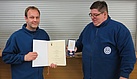 Kai Osterhage hält die Urkunde für das Silberne Feuerwehr- und Katastrophenschutzehrenzeichen in der Hand, das der Berliner Innensenator verleiht. Foto: THW/Anja Villwock