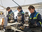 Die Jugendlichen vom THW Neukölln kennen sich genau mit der Petromax-Lampe aus und helfen beim Anzünden. Quelle: THW/Anja Villwock