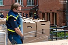THW-Helfer sichern die Kartons auf den Paletten mit Folie gegen Herabfallen. Quelle: THW/ Yannic Winkler