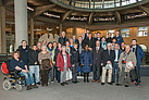 Ein Gruppenfoto vor dem Bundesadler im Plenarsaal des Deutschen Bundestages. Quelle: Deutscher Bundestag