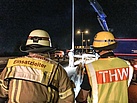Einsatzkräfte von THW und Feuerwehr beobachten gemeinsam das Niederlegen der Laterne auf der Rudolf-Wissel-Brücke. Quelle: THW/ Florian Knapp