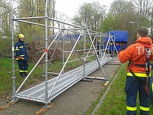 Das Einsatzgerüstsystem besteht aus verschieden langen Stangen, die an den Stielen verkeilt werden können. Mit dem System lassen sich verschiedene Konstruktionen errichten. Mit einem Trümmersteg kann man unebenes Gelände oder kleine Vertiefungen überbrücken. Das Quelle: THW/ Thomas Eick