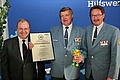 Herbert Kolar mit der Ehrenurkunde (Bildmitte), umgeben Manfred Metzger (Länderbeauftragter THW Berlin, re.) und Heinz Buschkowsky (Bezirksbürgermeister von Neukölln, li.). Foto: THW/Florian Knapp